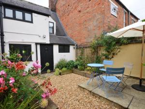 a small garden with a table and chairs in front of a house at 2 Bed in Winchcombe 47951 in Winchcombe