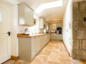a kitchen with white cabinets and a skylight at 3 Bed in Melbury Abbas 48804 in Melbury Abbas