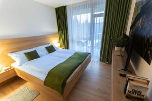1 dormitorio con cama grande y ventana grande en DAPELOVA Apartments - Tále, en Tale