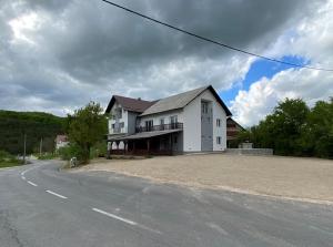 une grande maison blanche sur le côté d'une route dans l'établissement Soriso Gorici, à Otočac