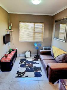 - un salon avec un canapé et une table dans l'établissement Theescombe Accomodation, à Port Elizabeth