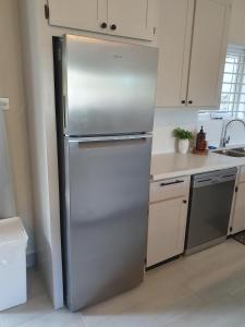 a stainless steel refrigerator in a kitchen at The Lane Rodney Bay 1 bedroom rate - Newly renovated & tastefully furnished 3 bedroom house home in Rodney Bay Village