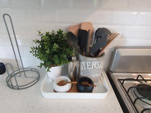 a container of utensils on a counter next to a sink at The Lane Rodney Bay 1 bedroom rate - Newly renovated & tastefully furnished 3 bedroom house home in Rodney Bay Village