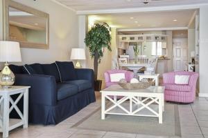 a living room with a blue couch and pink chairs at The Harbour #6 - 2 Bedrooms in Rodney Bay townhouse in Gros Islet