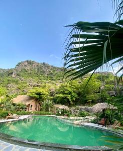 una piscina con una montagna sullo sfondo di Mường Village Ninh Bình a Ninh Binh