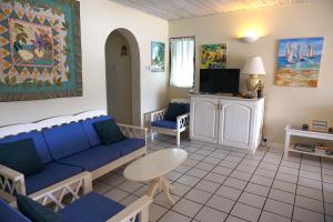 - un salon avec un canapé bleu et une table dans l'établissement Admiral's Quay #5 - Comfortable Townhouse townhouse, à Rodney Bay Village