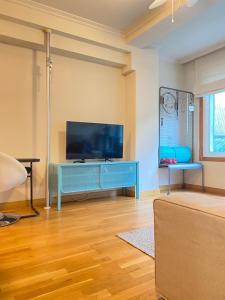 uma sala de estar com uma televisão e um armário azul em Moderno apartamento con encanto en el centro de Vigo em Vigo