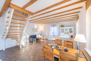 ein Wohnzimmer mit einem Holztisch und einer Küche in der Unterkunft Gutshaus Krimvitz Ferienwohnung auf Rügen in Putbus