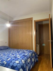 a bedroom with a blue and white bed and a door at Moderno apartamento con encanto en el centro de Vigo in Vigo