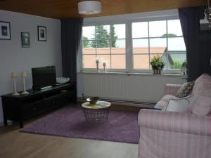 sala de estar con sofá y TV en Ferienwohnung Hinz, en Ellingstedt