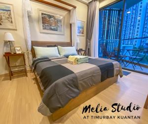 a bed in a room with a large window at TimurBay Seafront Residences by Melia Studio in Kuantan