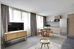 ein Wohnzimmer mit einem TV und einer Küche in der Unterkunft Pick A Flat's Apartments in Parc des Expositions - Rue Louis Vicat in Paris