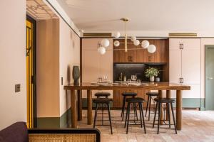 普羅旺斯艾克斯的住宿－法蘭西精神皮貢奈特酒店，厨房配有一张大木桌和凳子