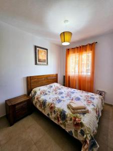 sypialnia z łóżkiem z kołdrą kwiatową w obiekcie CASA DEl SOL PLAYA PUERTO BLANCO w mieście Calpe +34 zdjęcia
