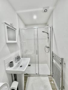 a white bathroom with a shower and a sink at Luxury Town Centre House, Faversham in Faversham