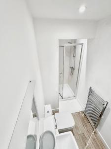 a white bathroom with a toilet and a shower at Luxury Town Centre House, Faversham in Faversham