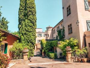 einen Innenhof eines Gebäudes mit Bäumen und Pflanzen in der Unterkunft Le Pigonnet - Esprit de France in Aix-en-Provence