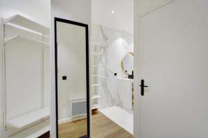 Puerta de cristal en una habitación blanca con espejo en Pick A Flat's Apartment in Place Vendôme/Tuileries - Rue Saint-Honoré, en París