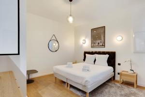 1 dormitorio con cama blanca y mesa en Pick A Flat's Apartment in Place Vendôme/Tuileries - Rue Saint-Honoré, en París