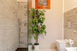 a bathroom with two potted plants in a shower at Casa Zito in San Giuliano Terme +19 photos