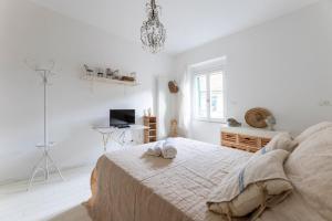 een witte slaapkamer met een bed en een bureau bij Pozzo Garitta, Borgo dei ceramisti, Albissola Marina in Albissola Marina