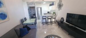 a living room with a television and a kitchen with a counter at JTower Royal Suites - Alefimmoed in Jerusalem +242 photos