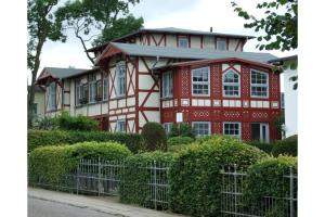 een rood-wit huis met een hek bij Villa Gundula nur 600m bis zum Ostseestrand in Zinnowitz