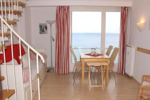 a dining room with a table and a view of the ocean at Apartmentvermittlung Mehr als Meer - Objekt 7 in Niendorf