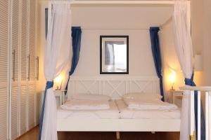a bedroom with two beds with blue curtains at Apartmentvermittlung Mehr als Meer - Objekt 7 in Niendorf +13 photos