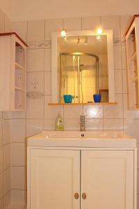 uma casa de banho com um lavatório e um espelho em Apartmentvermittlung Mehr als Meer - Objekt 7 em Niendorf