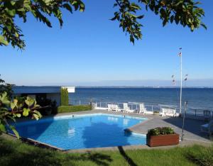 a swimming pool with the ocean in the background at Apartmentvermittlung Mehr als Meer - Objekt 7 in Niendorf