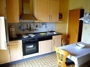 a kitchen with white cabinets and a stove and a table at Appartment 1070 im EG in Tossens in Butjadingen OT Tossens