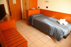 チェゼナーティコにあるHOTEL VILLA MARIAのベッドと電話が備わるホテルルームです。