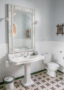 a white bathroom with a sink and a toilet at La Petite Calanque in Marseille