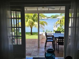an open door to a patio with a table and chairs at The Anchorage #5 a 3 bedroom Waterfront Condo in Rodney Bay condo in Gros Islet