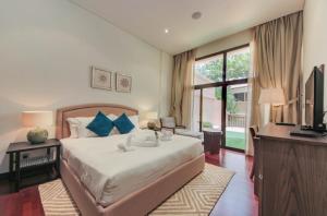 1 dormitorio con 1 cama, TV y escritorio en Luxe Getaways Royal Amwaj Palm Jumeirah Resort Apartment Holiday Home en Dubái