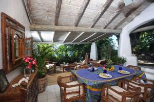 ein Esszimmer mit einem blauen Tisch und Stühlen in der Unterkunft Smuggler's Nest - Exotic & romantic villa villa in Cap Estate