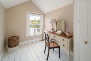 um quarto com uma secretária com um espelho e uma cadeira em Fern Cottage em Bembridge
