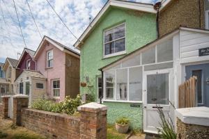 a green house with a white door at Fern Cottage in Bembridge