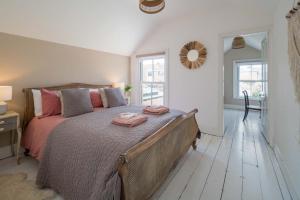 a bedroom with a large bed with two towels on it at Fern Cottage in Bembridge