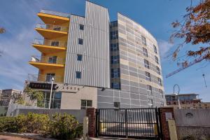 a tall glass building with a yellow at Premium Spacious Apartments at Paperbox Lofts in Salt Lake City in Salt Lake City