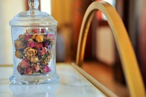 a glass jar filled with flowers sitting on a table at Vila Camélia in Porto
