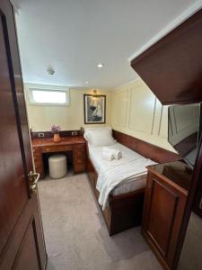 a small bedroom with a bed and a desk at Costa do Sal Hotel Boat Lounge in Aveiro