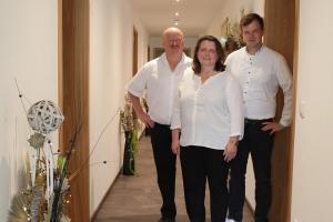 a woman and two men standing in a hallway at Gastwirtschaft & Hotel Doll in Markt Indersdorf