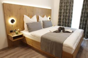 Markt IndersdorfGastwirtschaft & Hotel Doll的卧室里有一张带木质床头板的大床