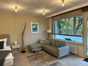 ein Wohnzimmer mit einem Sofa und einem Fenster in der Unterkunft Livingroom Mathildenhöhe in Darmstadt