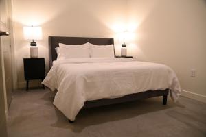 Premium Spacious Apartments at Paperbox Lofts in Salt Lake City في مدينة سولت ليك: غرفة نوم بسرير كبير وعليها مصباحين