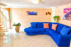- un canapé bleu dans le salon dans l'établissement Nonna Enza Apartment, à Atrani