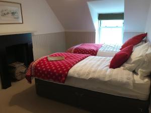 Un dormitorio con dos camas con mantas rojas y blancas. en The Bothy, Gallin, Glenlyon, Perthshire, en Bridge of Balgie