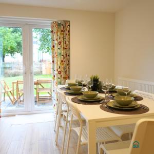 a dining room with a table with wine glasses on it at Summertown Oxford- Entire 4 bedroom home, sleeps up to 10- 10 mins to city centre in Oxford